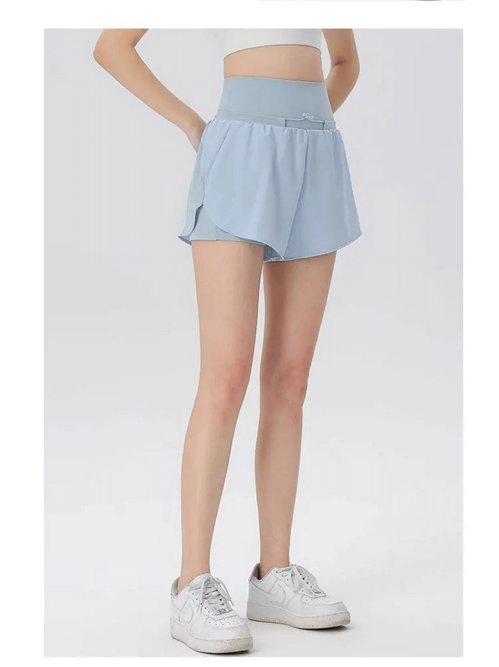 Woman wearing blue high waist athletic shorts, lightweight and breathable, ideal for gym or warm weather activities.